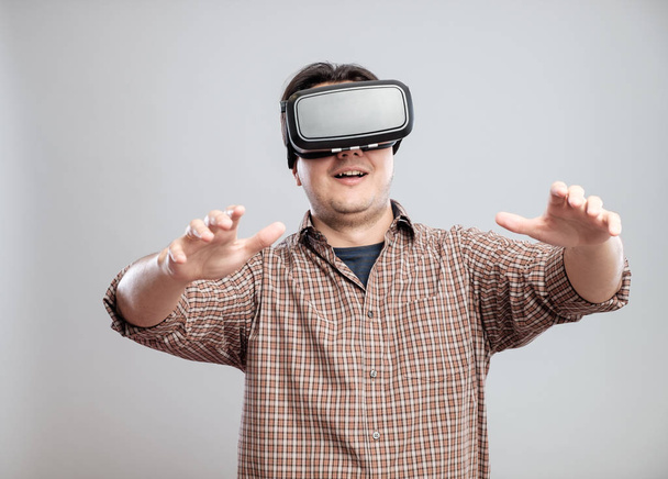 Happy young man using virtual reality headset - Foto, afbeelding