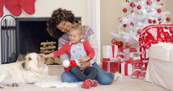 クリスマスの日に犬と幸せな母子 - 写真・画像