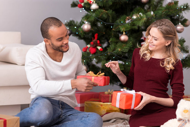 Positive delighted couple exchanging their presents - Foto, Bild