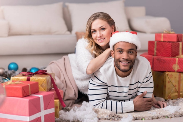 Pleasant young couple being surrounded by Christmas presents - Foto, Imagem