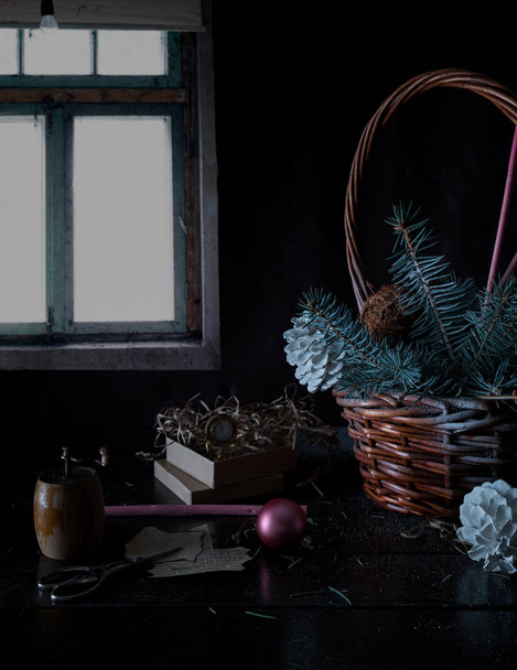 christmas, new year. basket with fir branches and cones on the background of the winter window. - Foto, Imagem