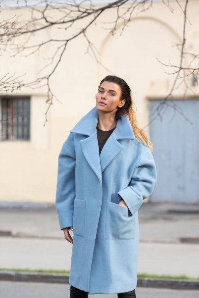 Модель в синем пальто с рукой в кармане
 - Фото, изображение
