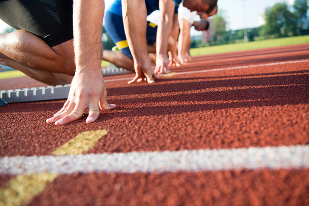 Personas listas para correr en el campo de atletismo
 - Foto, imagen
