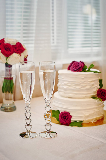 dwie szklanki szampana i tort weselny na stole - Zdjęcie, obraz