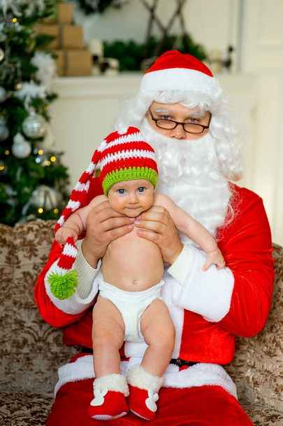 little baby in the arms of Santa Claus - Фото, изображение