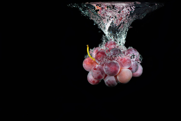 Uva rossa fresca in acqua con bolle d'aria spruzzi d'acqua
 - Foto, immagini