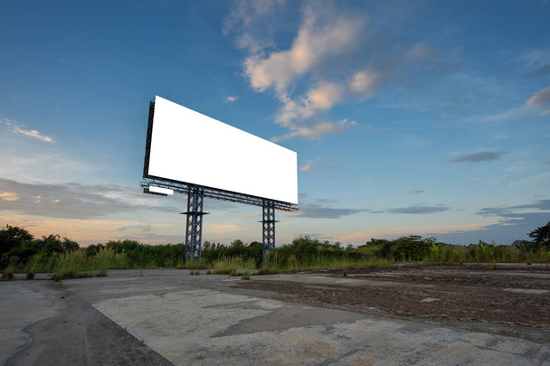 Blanco billboard met hemel bij zonsondergang klaar voor nieuwe reclame. - Foto, afbeelding