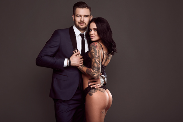 Portrait of a brutal man in suit and sexy girl - Photo, Image