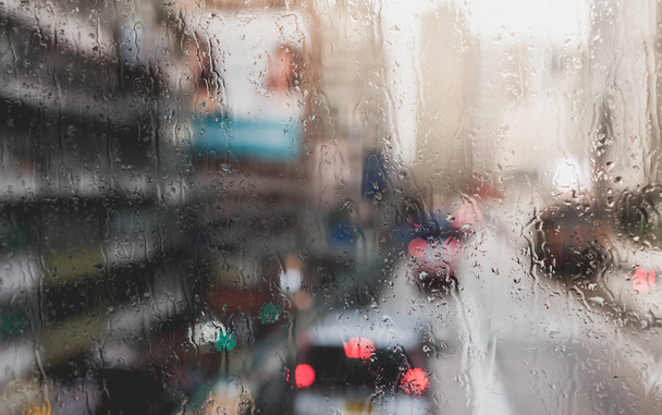 Goccia di pioggia offuscata sul vetro dell'autobus, Vista urbana delle gocce di pioggia cadere
 - Foto, immagini