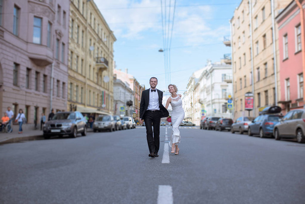 都市通りの上を歩いてのカップル - 写真・画像