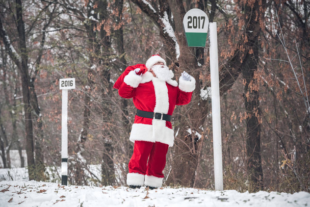 Santa Claus walking with sack on back - Фото, зображення