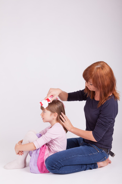 A mother is brushing her daughters hair - Photo, Image