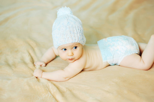 Маленький хлопчик у білому капелюсі на ковдрі
 - Фото, зображення