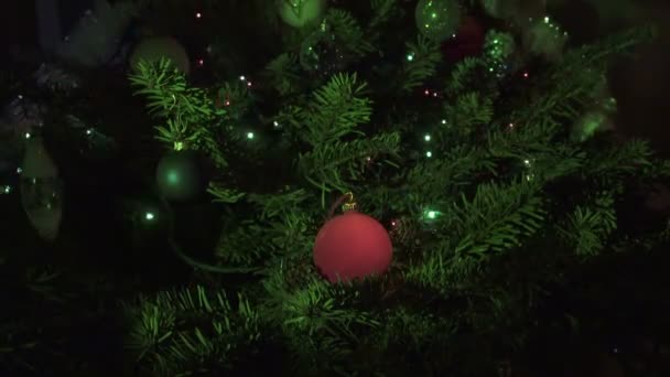 New Years ball against the background of the decorated garland of a Christmas tree - Footage, Video