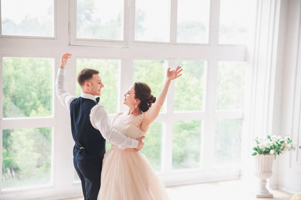 first wedding dance.wedding couple dances on the studio. Wedding day. Happy young bride and groom on their wedding day. Wedding couple - new family. Wedding dress. - Foto, immagini