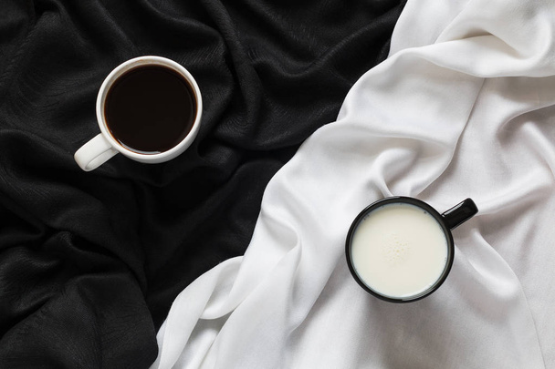 Two cups of coffee and milk on the black or white fabric. Top view. - Foto, Bild