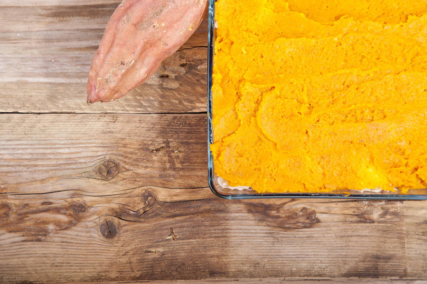Oven meal with sauerkraut and sweet potato on wooden background - Foto, afbeelding