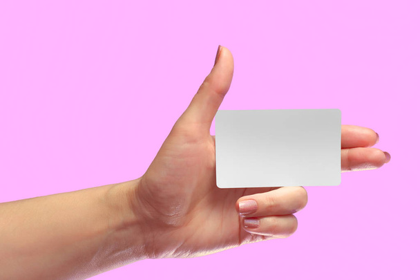 Ліва рука тримає порожню білу картку макет. SIM-карта стільникового зв'язку Пластикова NFC Smart Tag Call-card Mock Up Template. Кредитна картка або транспортний квиток. Різдвяний магазин знижка подарунок лояльності. Копіювати простір
. - Фото, зображення