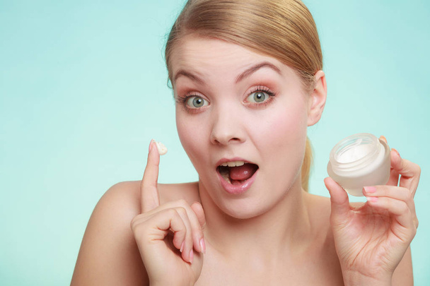 woman applying cream on her skin face. - Фото, изображение