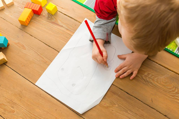 Malé dítě kreslení tužkou na bílém papíře - Fotografie, Obrázek