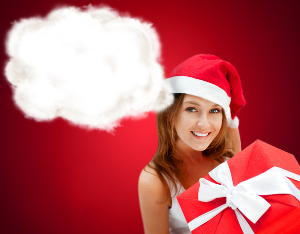Young happy girl in Christmas hat. Holding huge christmas gift. - 写真・画像