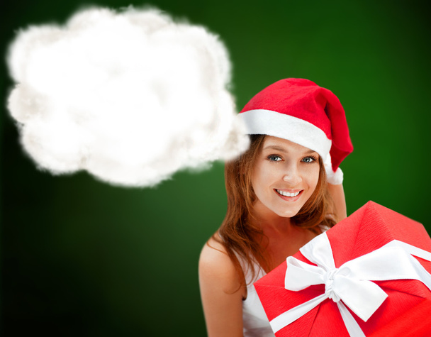 Young happy girl in Christmas hat. Holding huge christmas gift. - Foto, Bild