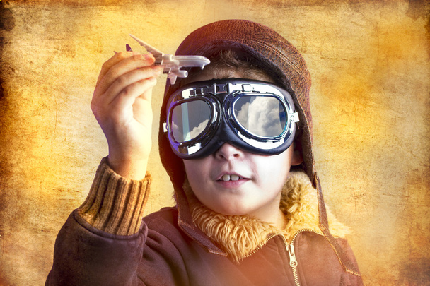 taiteellinen muotokuva lapsesta, jolla on entinen lentopuku, hattu ja
 - Valokuva, kuva