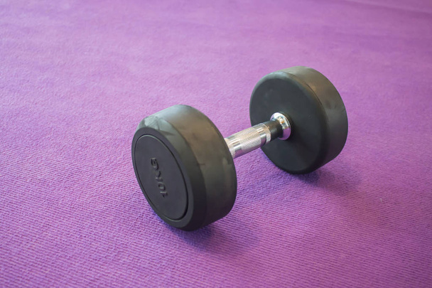 Fitness exercise equipment dumbbell weight on purple background - Photo, Image
