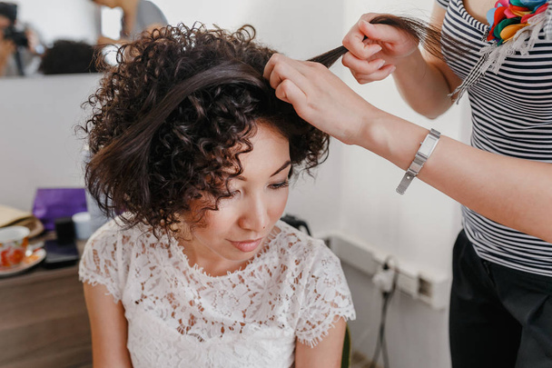 Kuaför Salonu, kısa kıvırcık sağlıklı koyu saçlı esmer kız saç modeli yapma - Fotoğraf, Görsel