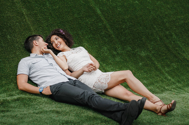 couple in love lying on green artificial grass - Fotografie, Obrázek