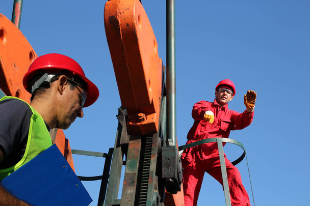 Olieveld werknemers bij de oliebron  - Foto, afbeelding