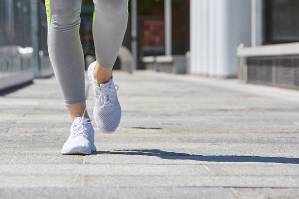 Woman running in the city with tracksuit and white shoes - Foto, immagini
