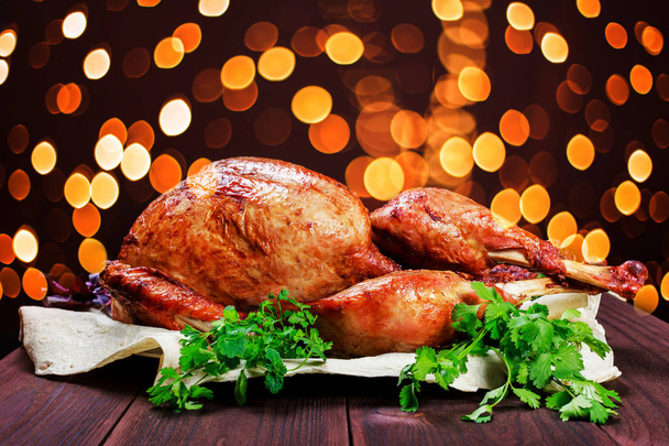 Geroosterde Turkije. Thanksgiving tafel geserveerd met Turkije, versierd met Groenen en basilicum op donkere houten achtergrond. Zelfgemaakte gebraden kip. Kerst diner van de vakantie - Foto, afbeelding