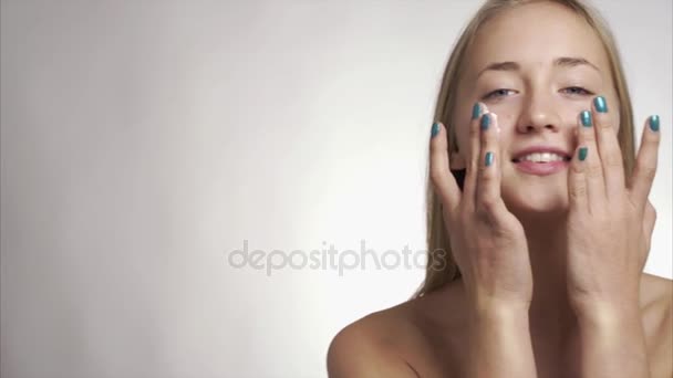 girl using care skin products on face - Кадри, відео