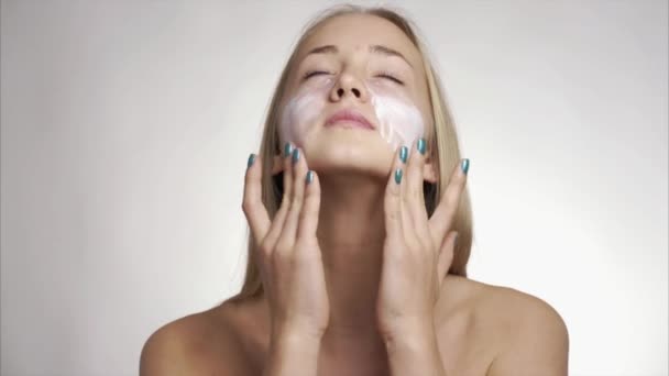girl using care skin products on face - Imágenes, Vídeo