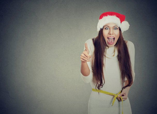 Christmas woman excited about weight loss measuring waist  - Zdjęcie, obraz