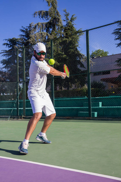 Профессиональный теннисист играет в теннис на корте
.  - Фото, изображение