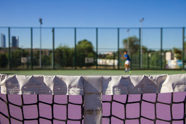 Foto Red cancha de tenis cerrar en un día soleado. La red está centrada
. - Foto, Imagen