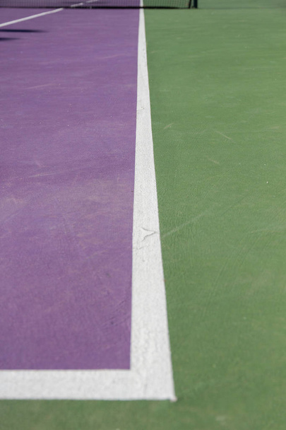Linie na rogach kort tenisowy cementu. Torze kolory są fioletowe i zielone.  - Zdjęcie, obraz