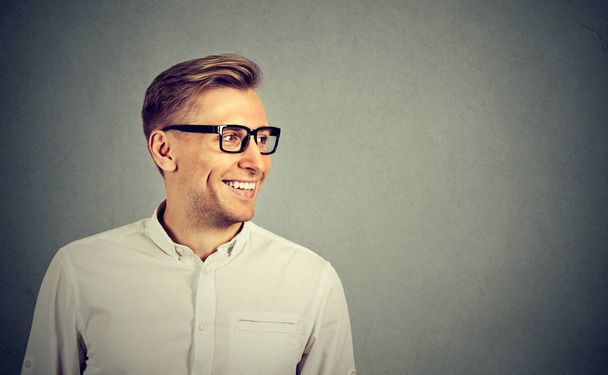Young man with glasses smiling looking to the side  - Photo, image