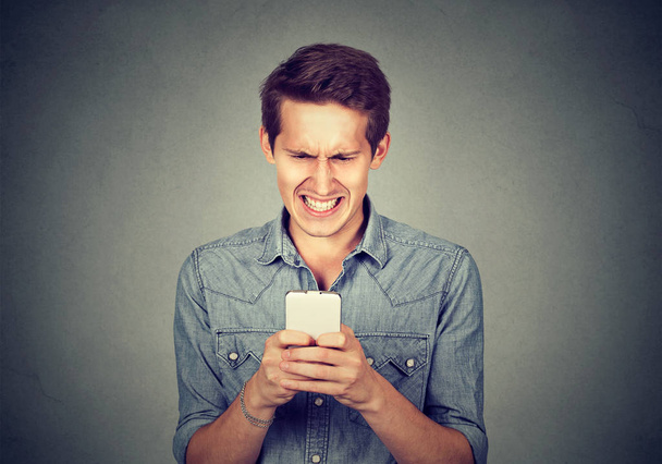 Homem enojado lendo uma mensagem de texto
 - Foto, Imagem