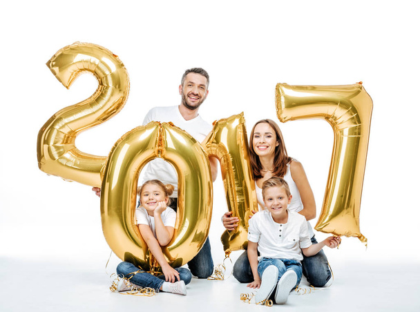 Familia feliz sosteniendo globos dorados
  - Foto, Imagen
