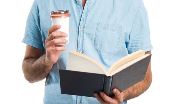 Όμορφος άντρας με τα μπλε γυαλιά ανάγνωσης βιβλίου και πίνοντας τον καφέ - Φωτογραφία, εικόνα