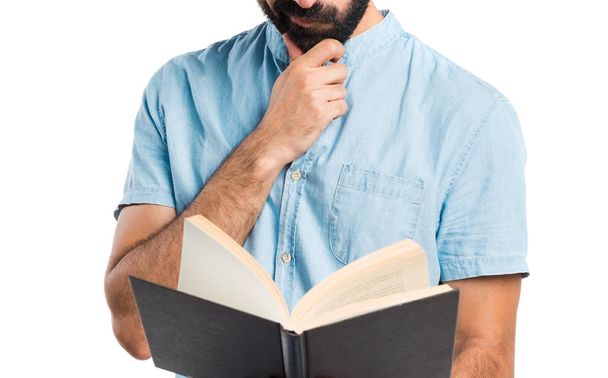 Όμορφος άντρας με τα μπλε γυαλιά ανάγνωσης βιβλίου - Φωτογραφία, εικόνα