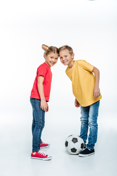 siblings standing with soccer ball - 写真・画像