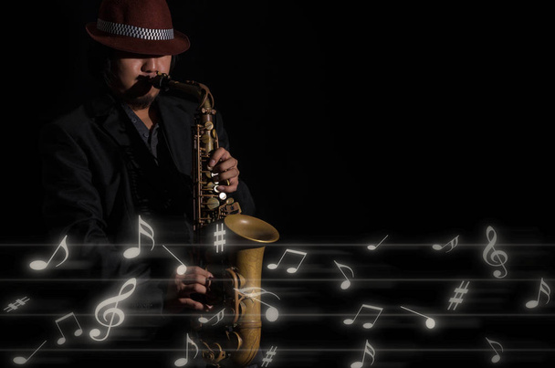 саксофонист на темном фоне
 - Фото, изображение