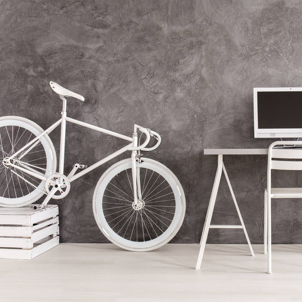 Grey room with bike and desk - Foto, afbeelding