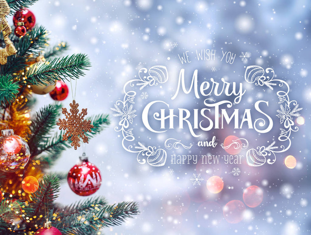 Xmas tree background and Christmas decorations with blurred, sparking, glowing and text Merry Christmas and Happy New Year - Photo, Image