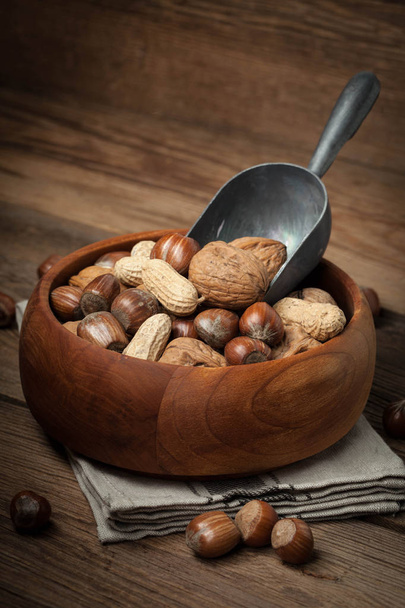 Walnuts, hazelnuts and peanuts in wooden bowl. - Foto, Bild