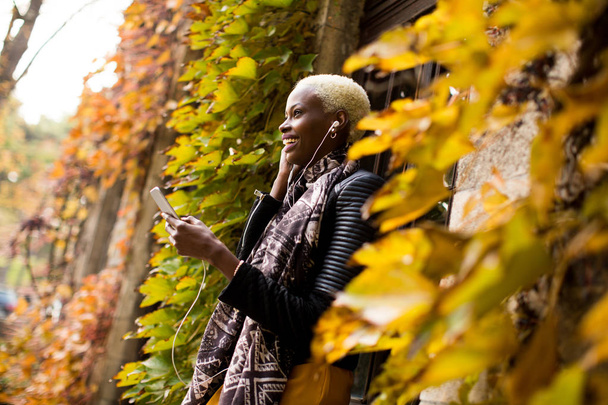 Молода чорна жінка з мобільним телефоном
 - Фото, зображення